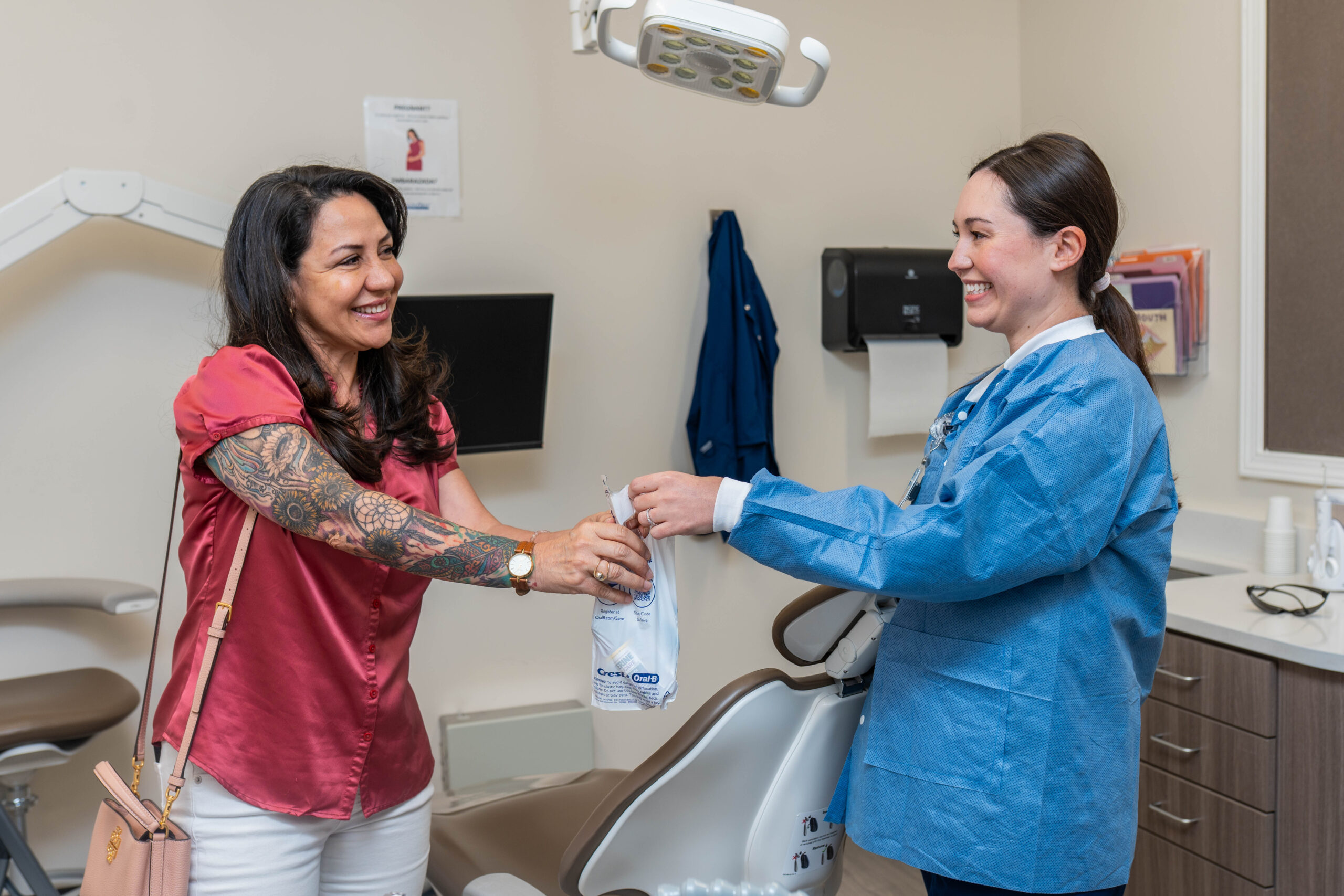 HealthFirst Dentist giving a patient a dental care goodie bag after completing their appointment